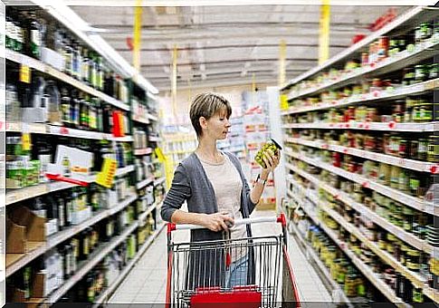 A woman with a shopping cart in the supermarket.