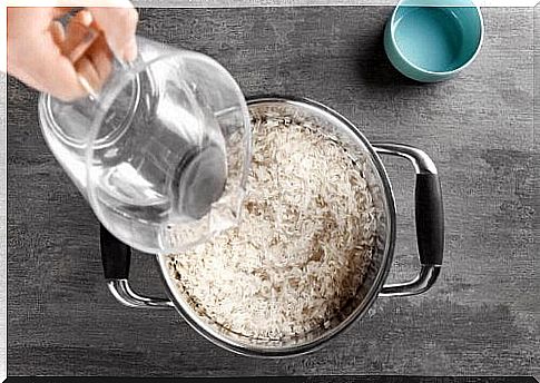 Some water is poured into a saucepan with rice.