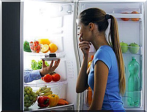 Woman in front of the fridge eats too much in the evening